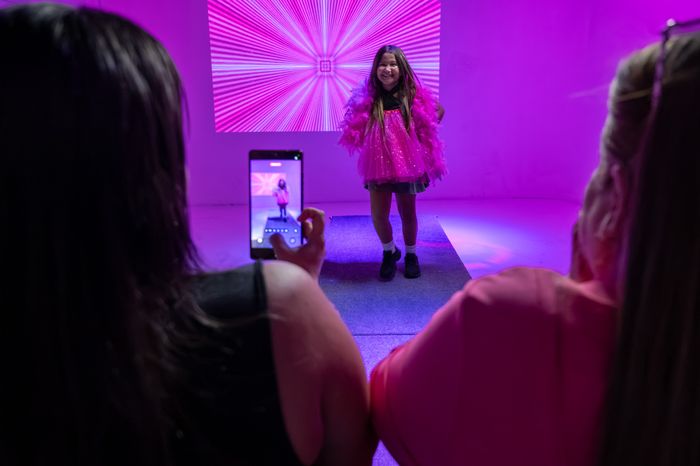 Girl smiling on the illuminated runway as her photo is taken