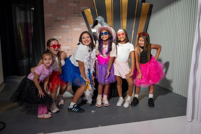 The full group of girls posing together in their party outfits and sunglasses